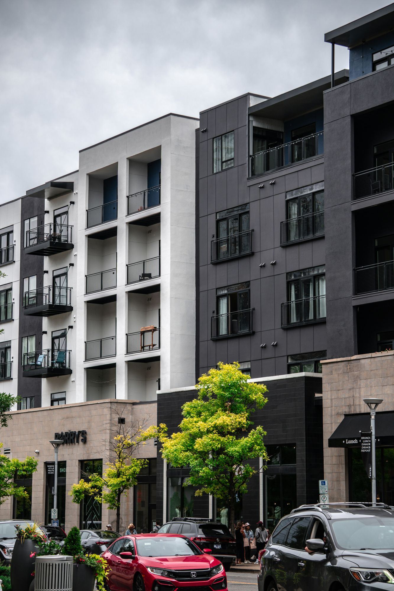 A modern mixed-use multifamily building with street-level retail.